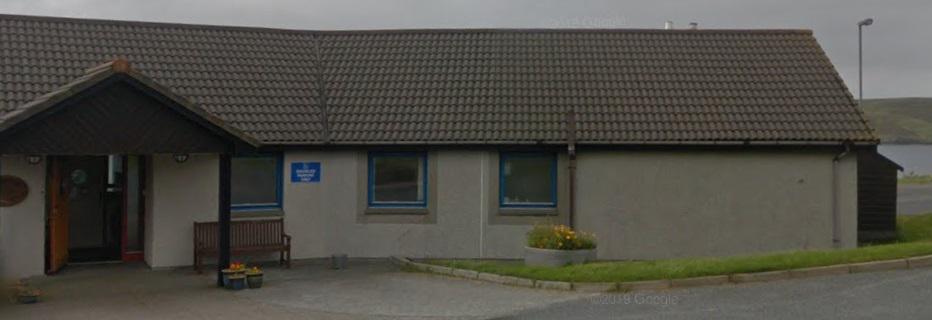 Front of care home building showing an open door.